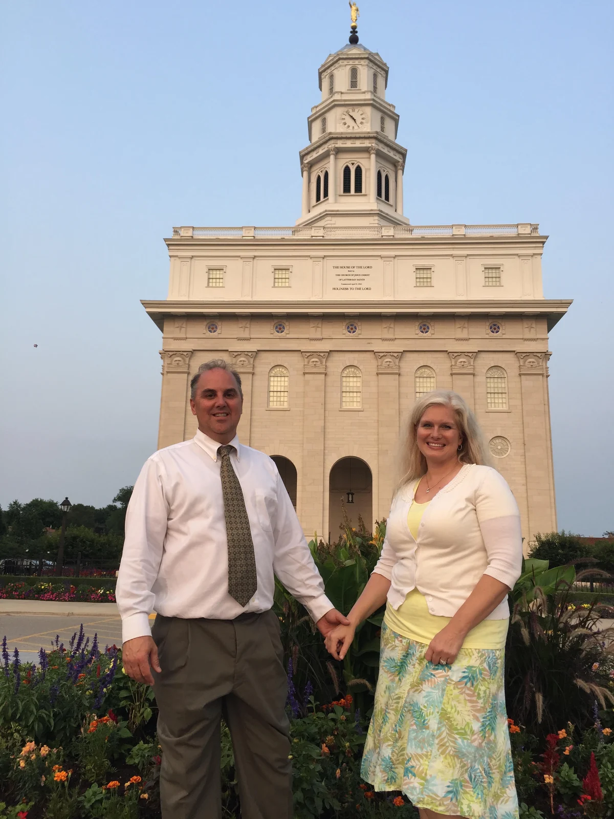 Rick and Amy holding hands outside a temple during their travels